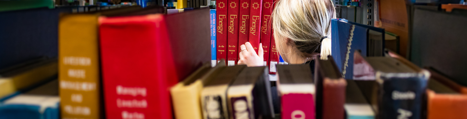 Student searching for a book in McLaughlin Library at the University of Guelph