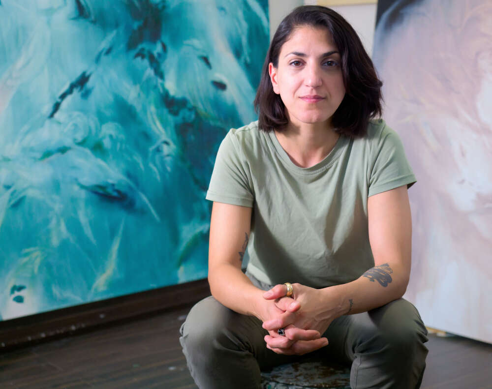 Portrait of Chantal Khoury in front of one of her paintings