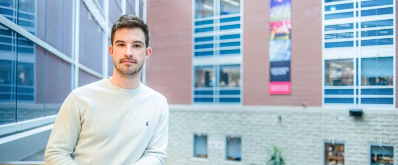 Portrait of graduate student Eric Lawton (PhD, Biomedical Sciences with Neuroscience) in the Science Atrium at the University of Guelph