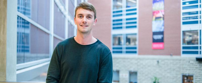 Profile of graduate student Matthew Rudland (MSc, Environmental Sciences) in the atrium of Mac Donald Stewart Hall at the University of Guelph