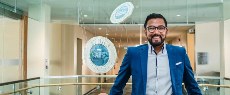 Portrait of graduate student Caleb Sawh (MSc, Marketing & Consumer Studies) in the atrium of MacDonald Stewart Hall at the University of Guelph