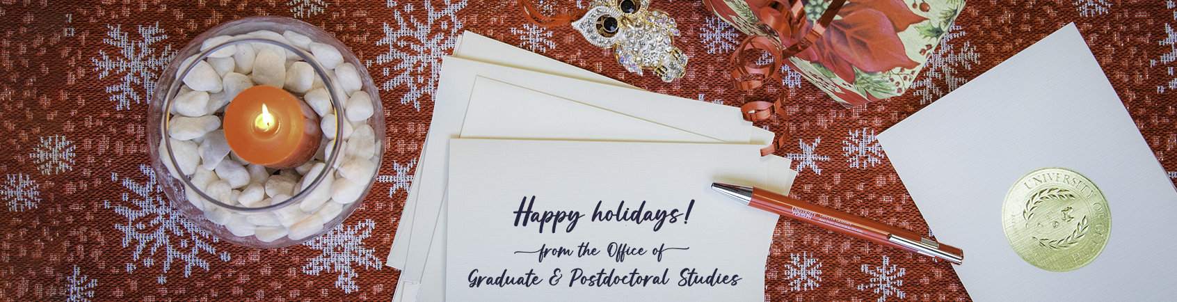 Pen, owl, present, candle and a card with a holiday greeting 