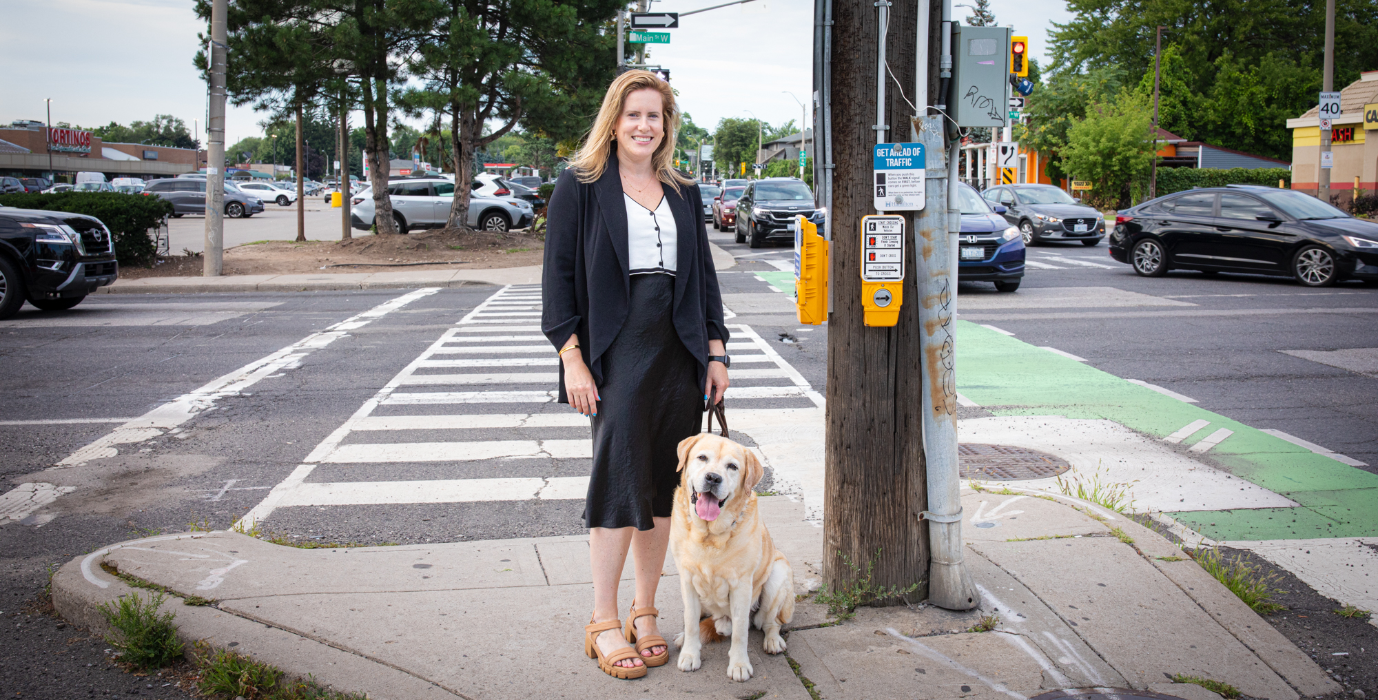 Portrait of PhD grad student Emma Harris on a sidewalk with her dog