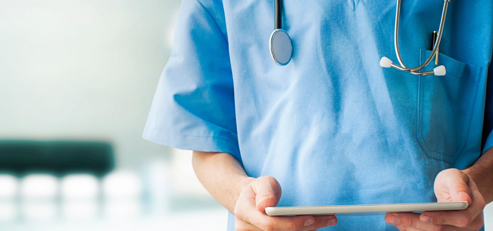 Physician in scrubs holding an iPad