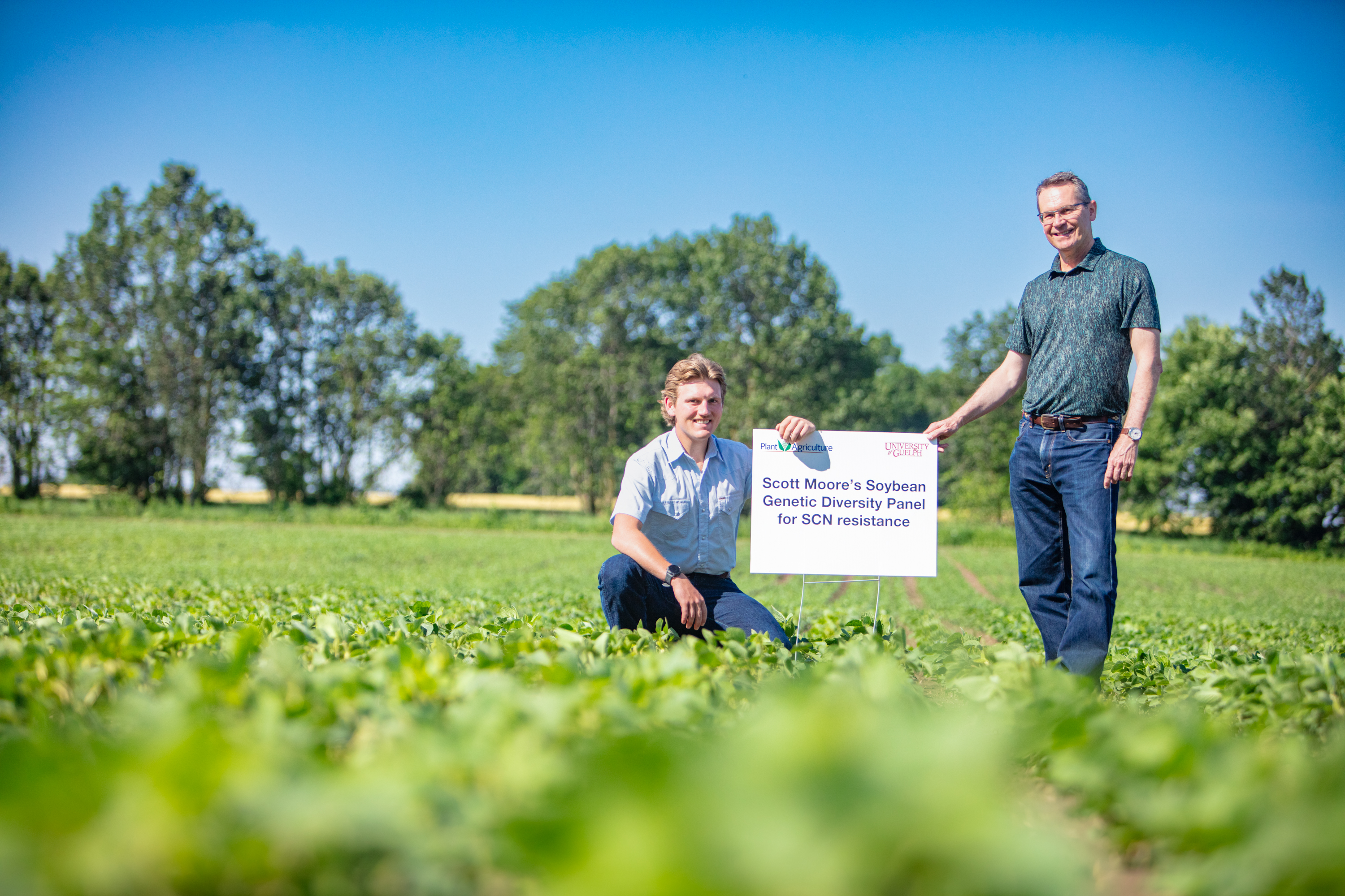 U of Guelph Plant Agriculture grad student Scott Moore with his advisor. Prof. Istvan Rajcanin a field of soybeans