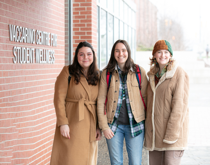 3 grad students in front of the Vaccarino Centre for Student Wellness