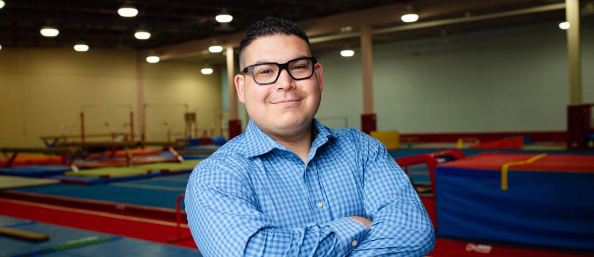 U of G MSc Management student, Tyler Tap Young in front of a gymnastics facility